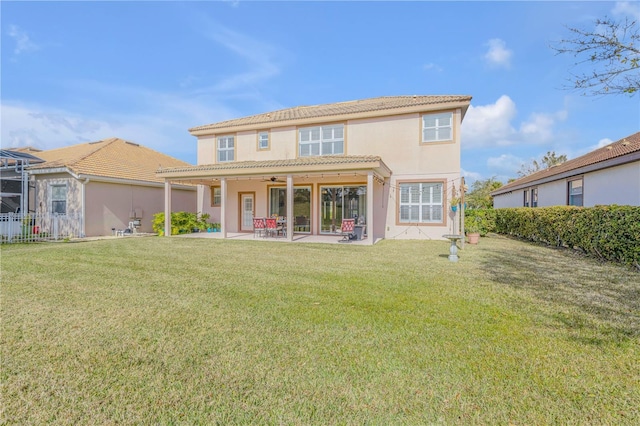 rear view of house with a patio and a yard