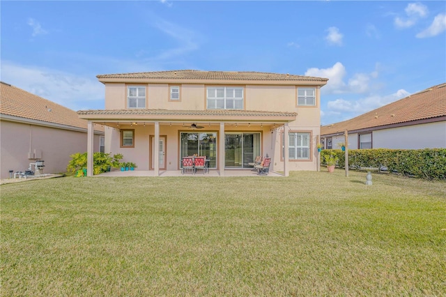 rear view of property featuring a patio, ceiling fan, and a lawn