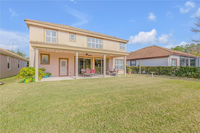 back of house with a patio, ceiling fan, and a lawn