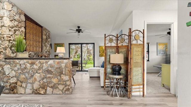 living area with vaulted ceiling, ceiling fan, and light hardwood / wood-style floors