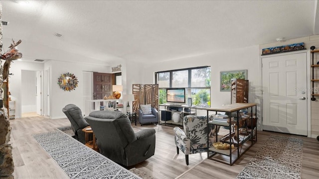 living room with light hardwood / wood-style floors and a textured ceiling