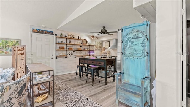 dining room with a textured ceiling, light hardwood / wood-style flooring, and ceiling fan