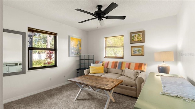 living room with ceiling fan, carpet, and a textured ceiling