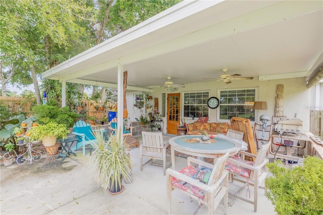 view of patio with ceiling fan, outdoor dining area, and fence