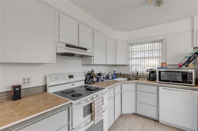 kitchen featuring white cabinetry, white appliances, a textured ceiling, and light tile patterned flooring