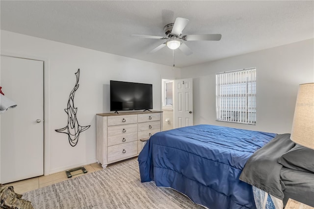 tiled bedroom with ceiling fan and a textured ceiling