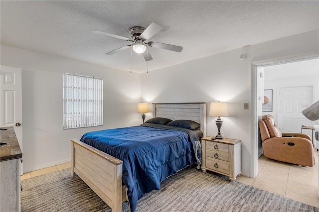 bedroom featuring ceiling fan, a textured ceiling, and light tile patterned flooring