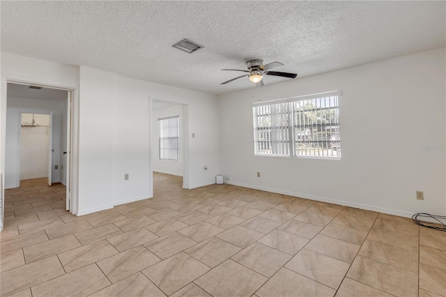 empty room featuring ceiling fan and a textured ceiling