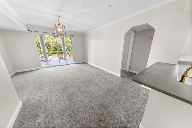 unfurnished living room featuring an inviting chandelier, crown molding, a textured ceiling, and carpet