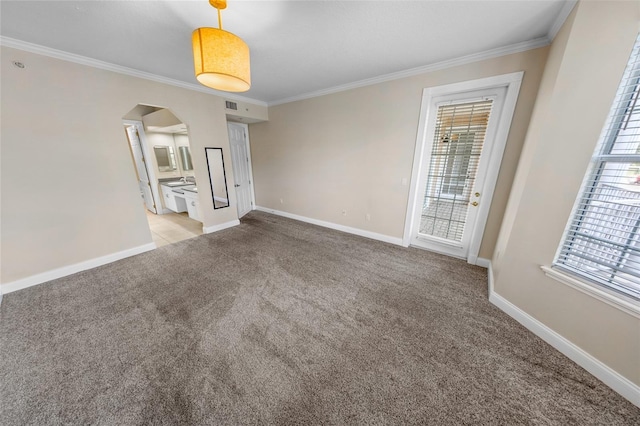 empty room featuring light colored carpet, ornamental molding, and a wealth of natural light