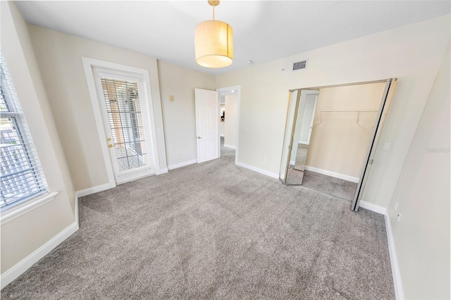 unfurnished bedroom featuring carpet flooring and a closet