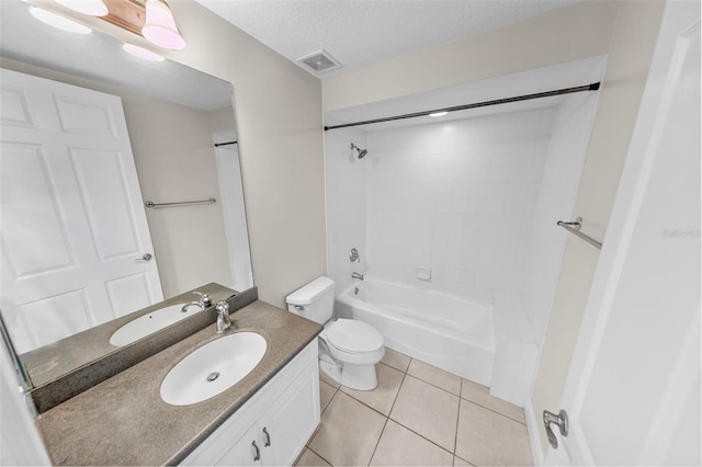 full bathroom with tiled shower / bath combo, vanity, toilet, tile patterned floors, and a textured ceiling