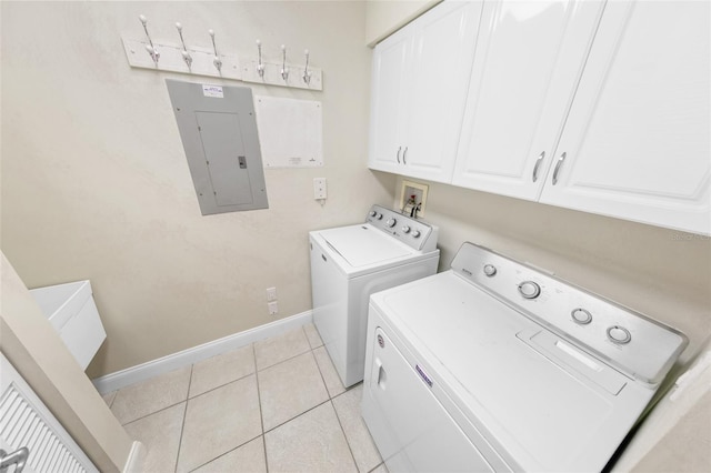 clothes washing area with cabinets, washing machine and clothes dryer, electric panel, and light tile patterned floors