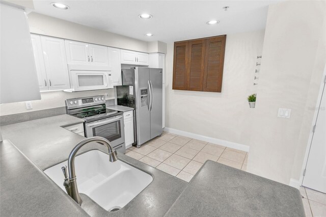 kitchen featuring white cabinetry, sink, light tile patterned flooring, and appliances with stainless steel finishes