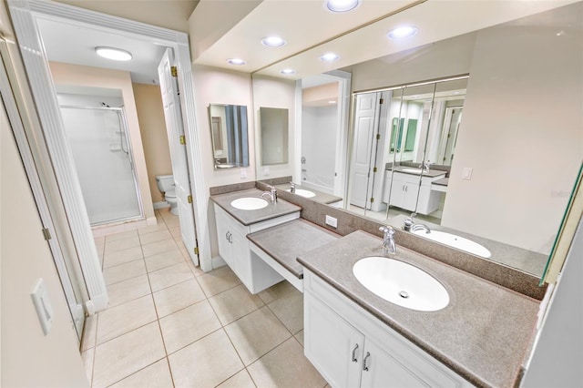 bathroom featuring vanity, toilet, a shower with shower door, and tile patterned flooring