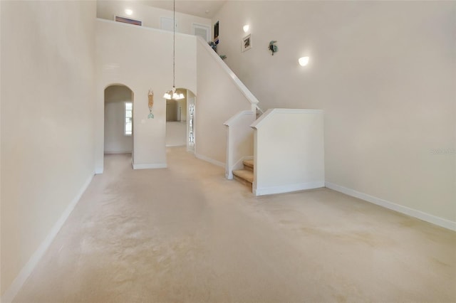 bonus room with carpet, a towering ceiling, and a chandelier