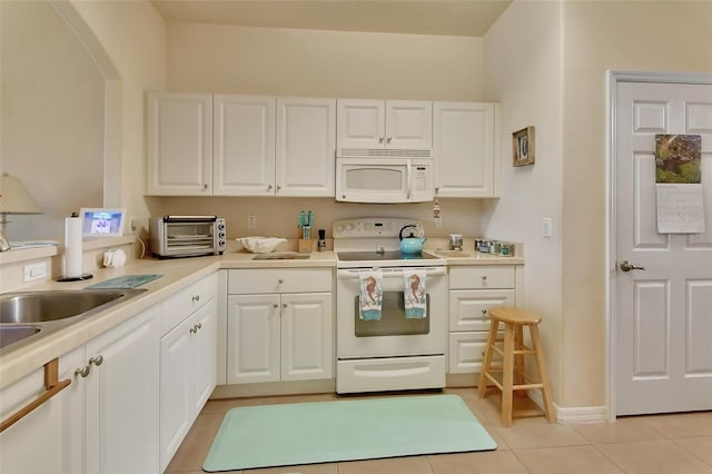 kitchen with white cabinetry, white appliances, and light tile patterned floors