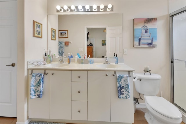 bathroom with tile patterned floors, vanity, toilet, and a shower with shower door