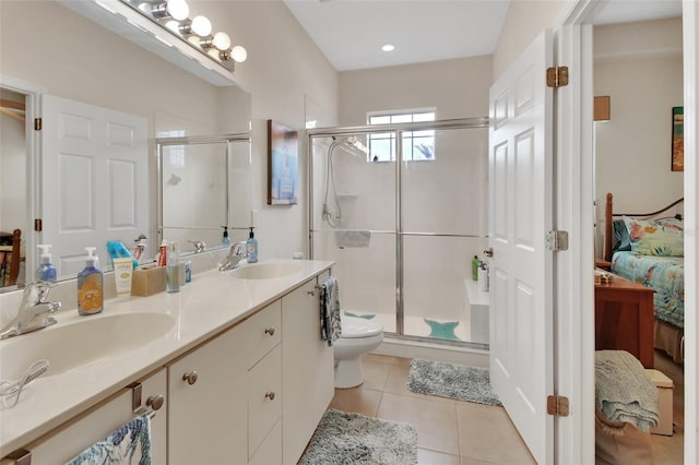 bathroom with a shower with door, vanity, tile patterned floors, and toilet