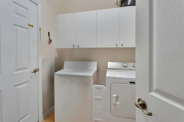 washroom with cabinets and washer and dryer