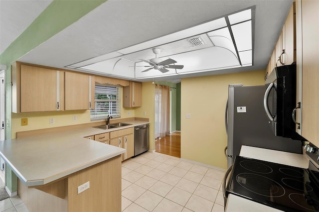 kitchen featuring visible vents, a peninsula, stainless steel appliances, a sink, and light tile patterned flooring