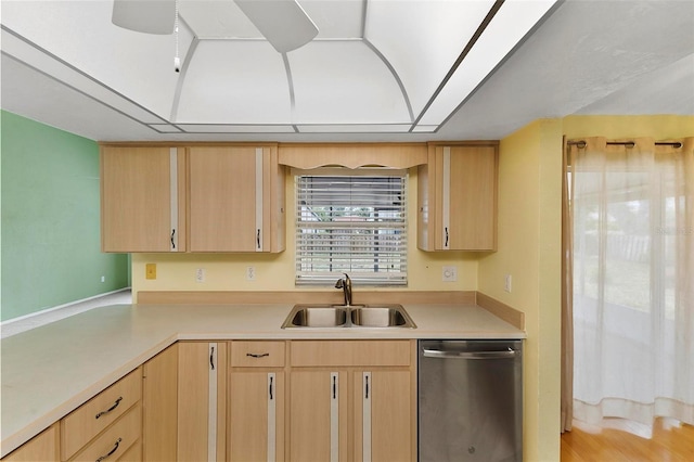 kitchen with light countertops, dishwasher, a sink, and light brown cabinetry