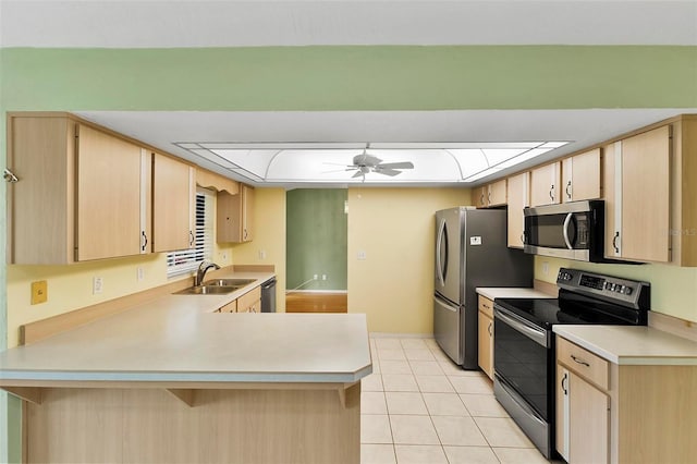 kitchen featuring a sink, stainless steel appliances, a peninsula, and light brown cabinets