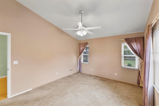 spare room featuring vaulted ceiling, carpet, a ceiling fan, and baseboards