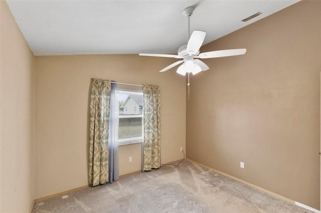 carpeted spare room featuring baseboards, visible vents, and a ceiling fan