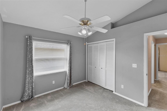 unfurnished bedroom featuring vaulted ceiling, a closet, carpet, and baseboards