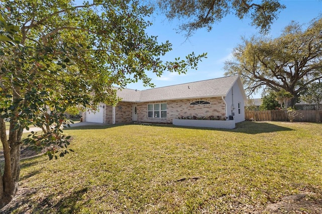 back of house featuring a garage, brick siding, a lawn, and fence