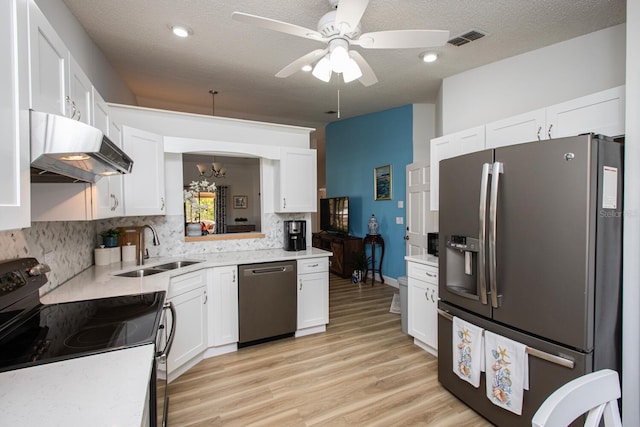 kitchen featuring sink, light wood-type flooring, stainless steel appliances, decorative backsplash, and white cabinets