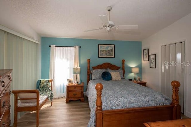 bedroom featuring ceiling fan, a textured ceiling, and light wood-type flooring