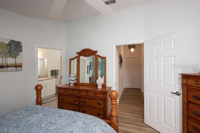 bedroom with ensuite bath and light hardwood / wood-style floors