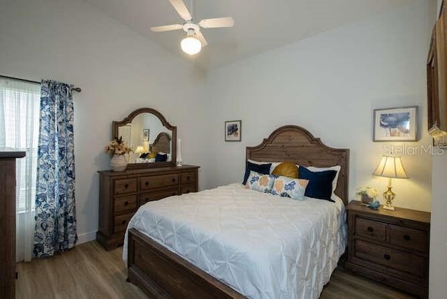 bedroom with dark wood-type flooring, ceiling fan, and lofted ceiling