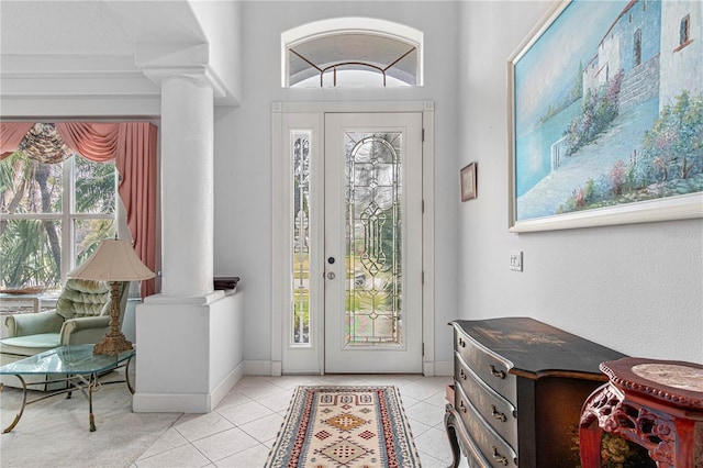 entrance foyer featuring light tile patterned floors and ornate columns