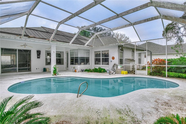 view of swimming pool featuring a patio area, ceiling fan, and glass enclosure