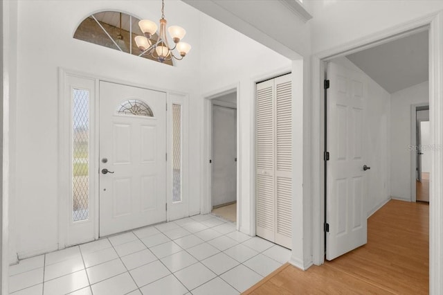 tiled entryway featuring a chandelier