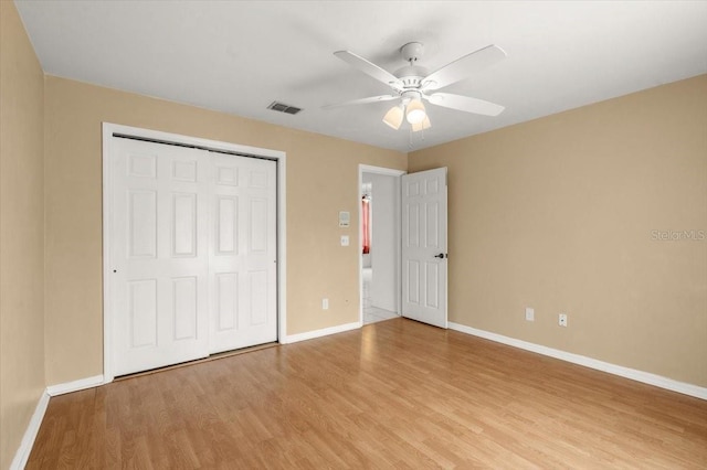 unfurnished bedroom with light hardwood / wood-style floors, a closet, and ceiling fan