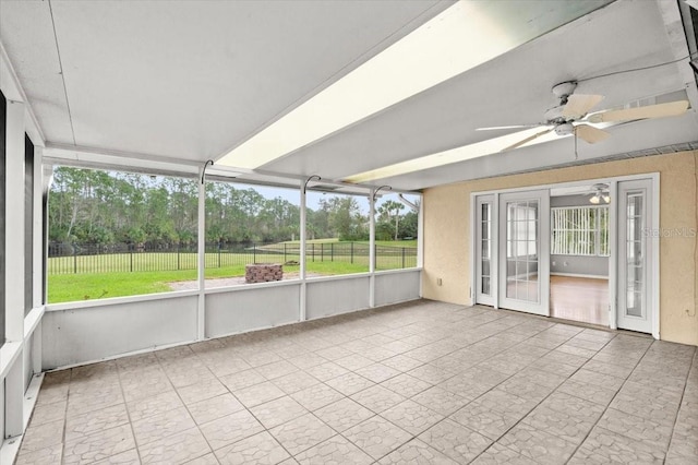 unfurnished sunroom with a wealth of natural light and ceiling fan