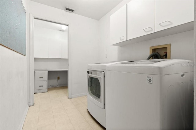 washroom with washing machine and dryer and cabinets