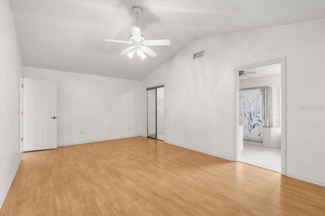 unfurnished room with ceiling fan, lofted ceiling, and light wood-type flooring