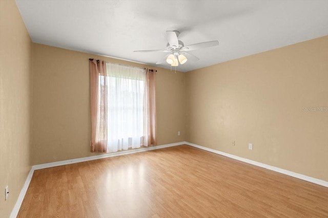 spare room with ceiling fan and light wood-type flooring