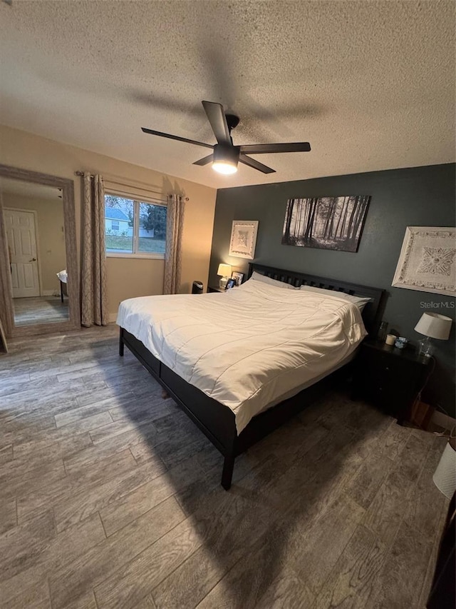 bedroom featuring a textured ceiling, a ceiling fan, and wood finished floors