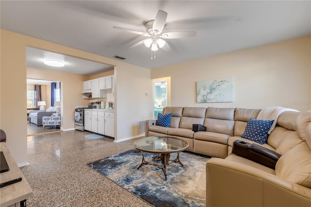 living room featuring a textured ceiling and ceiling fan