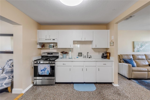 kitchen featuring tasteful backsplash, white cabinetry, sink, gas stove, and a textured ceiling