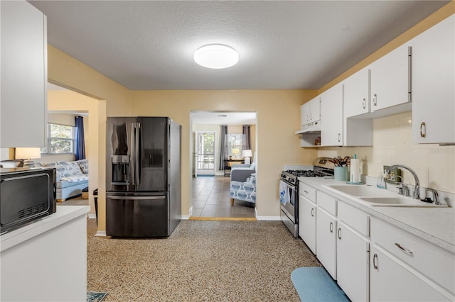 kitchen with sink, black appliances, a textured ceiling, white cabinets, and decorative backsplash