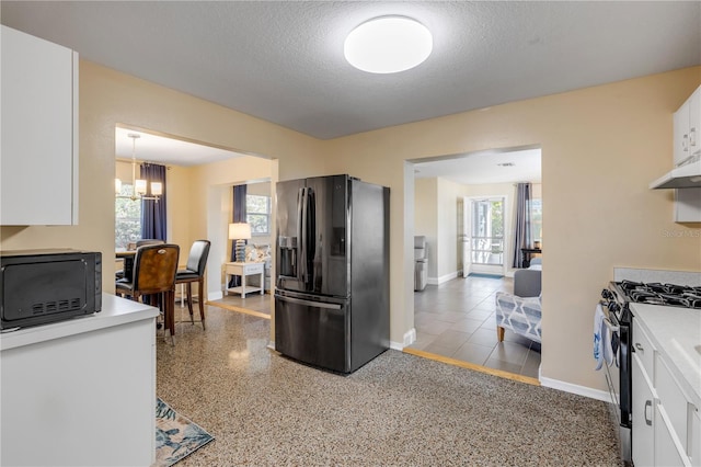 kitchen featuring plenty of natural light, decorative light fixtures, white cabinets, and black appliances