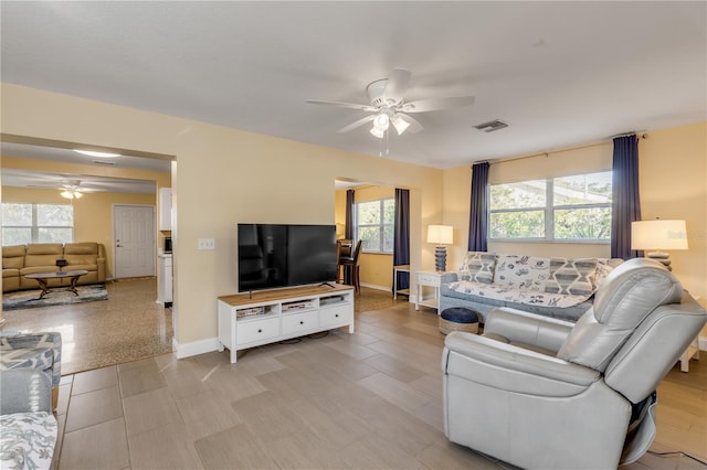 living room with a healthy amount of sunlight and ceiling fan