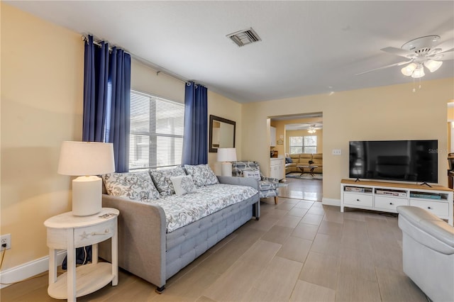 living room featuring a wealth of natural light and ceiling fan